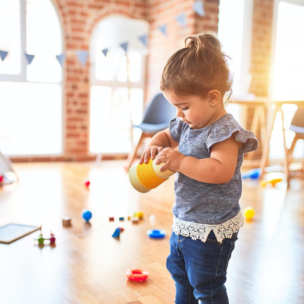 Toddler in pre-school holding a toy